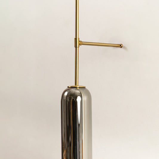 Closeup of gold metal wall pendant light with chrome finish tube shade showcasing sleek modern design for interior decor styling.