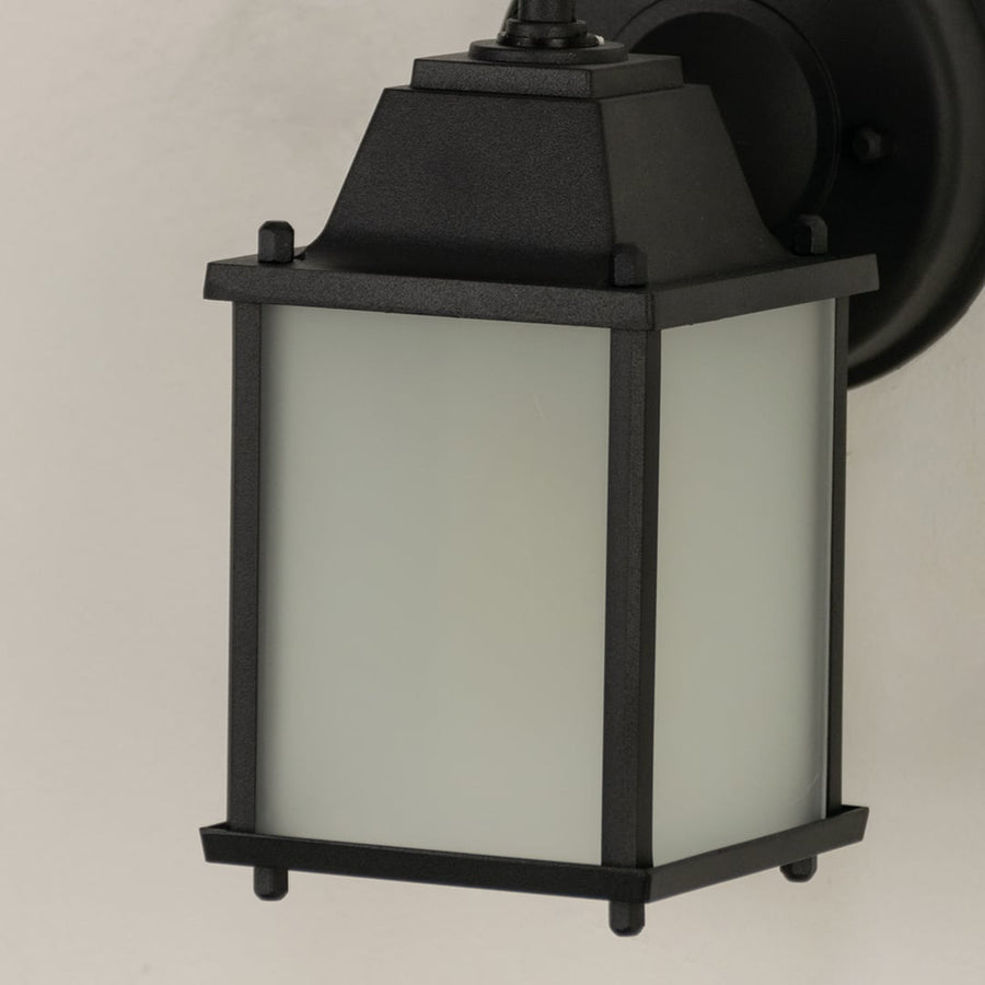 A detailed close view of the lantern top showing the loop finial and angled roof shape highlighting the solid build and clean edges suited for modern outdoor decor.