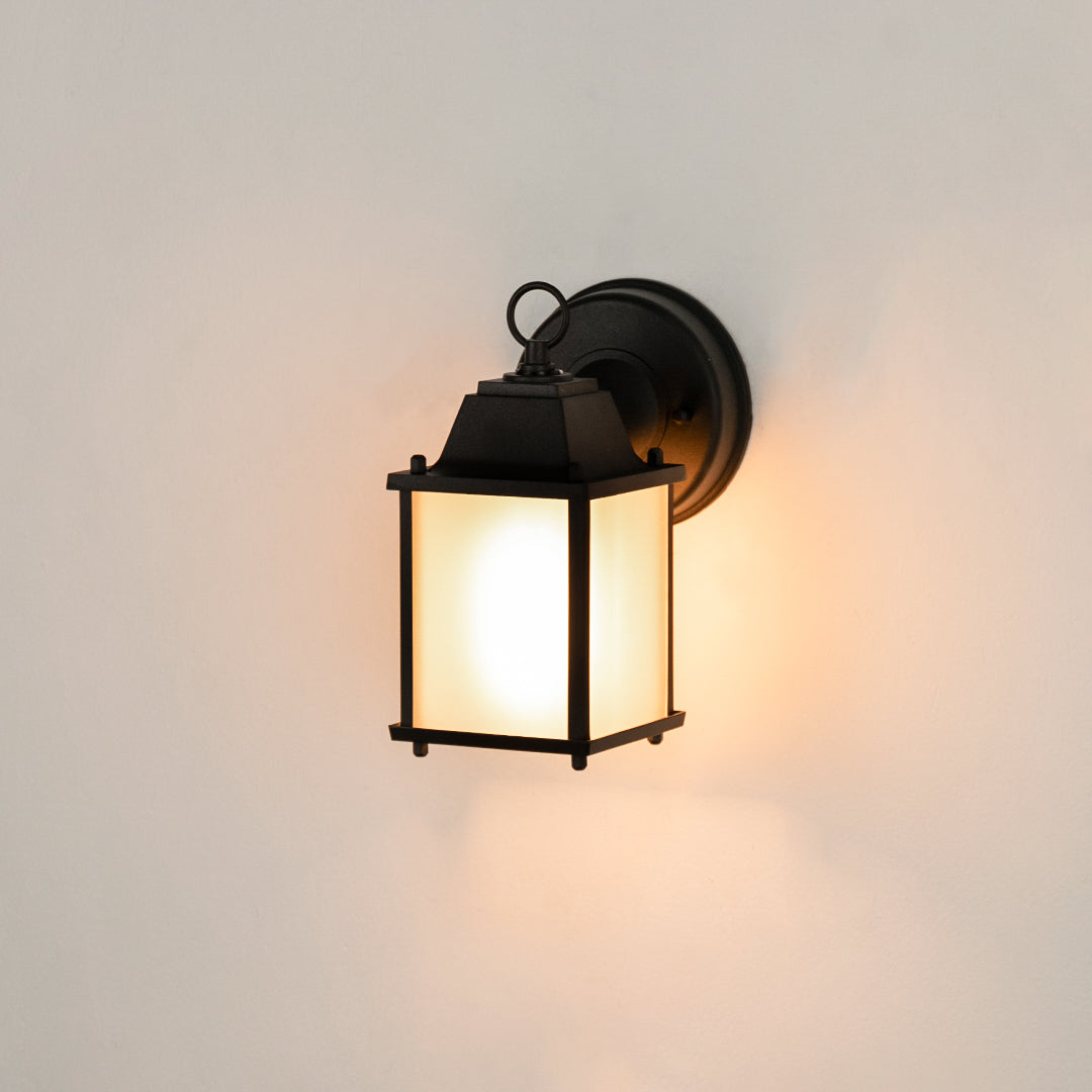 Modern black rectangular outdoor wall light on white background with frosted glass panels for minimalist patio decor.