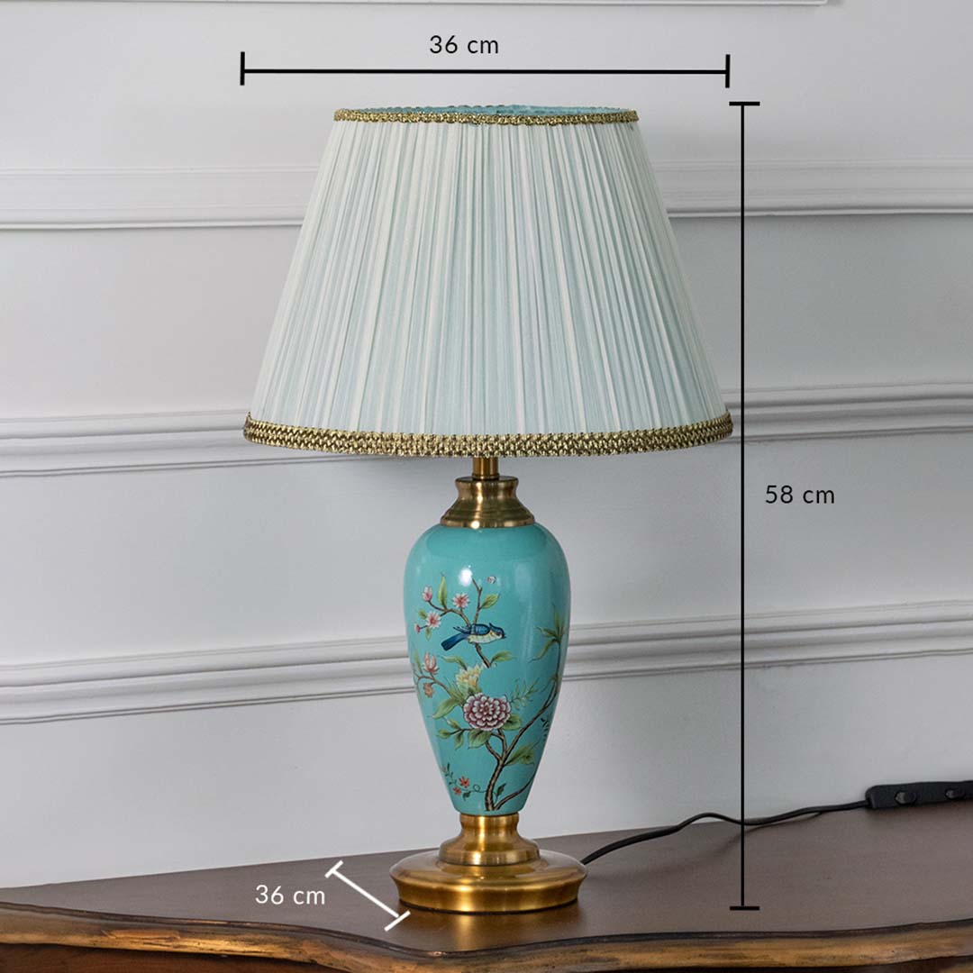 Turquoise floral ceramic table lamp with gold base and pleated shade displayed on white background featuring height 58 cm and width 36 cm for precise measurement.
