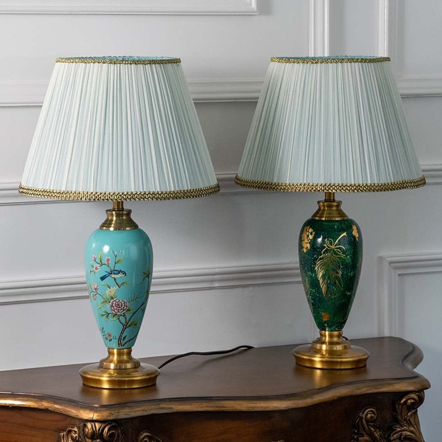 Elegant turquoise ceramic table lamp with gold base and floral artwork turned off on white background showcasing fine craftsmanship and vintage elegance.