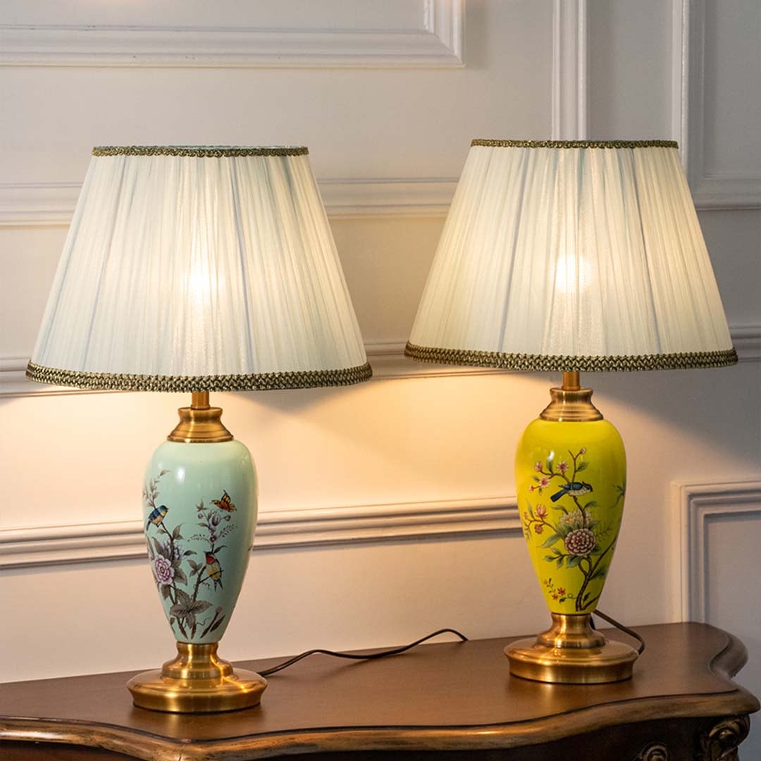 Set of colorful floral ceramic lamps glowing beautifully with soft ambient light against beige background showcasing artisanal craftsmanship and rich color contrast.