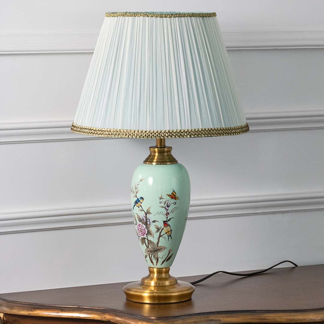 Mint green hand-painted floral table lamp turned off on white background showcasing intricate design and smooth glossy finish.