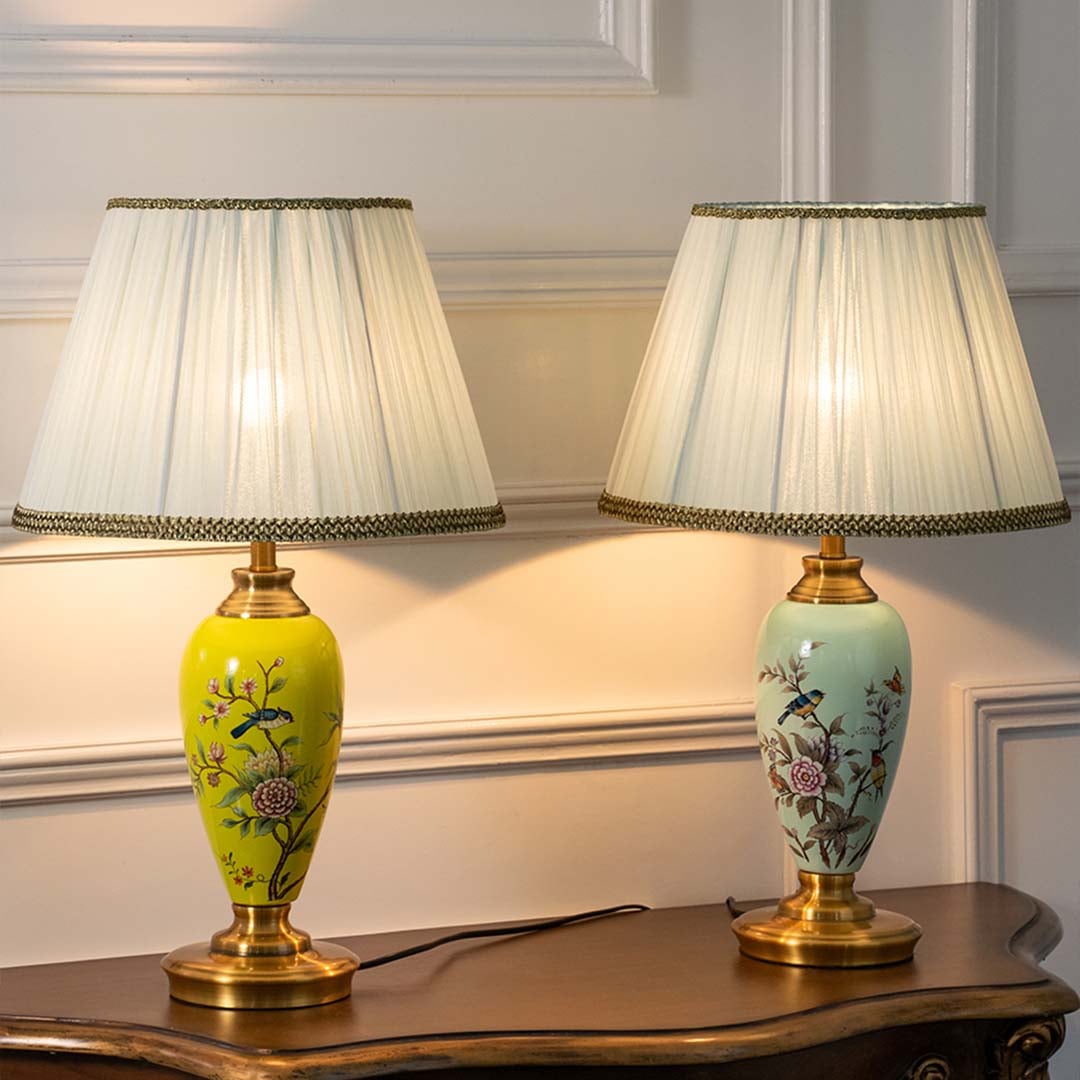Four floral ceramic lamps with golden bases and pleated white shades glowing warmly against beige background creating a luxurious ambient setup.