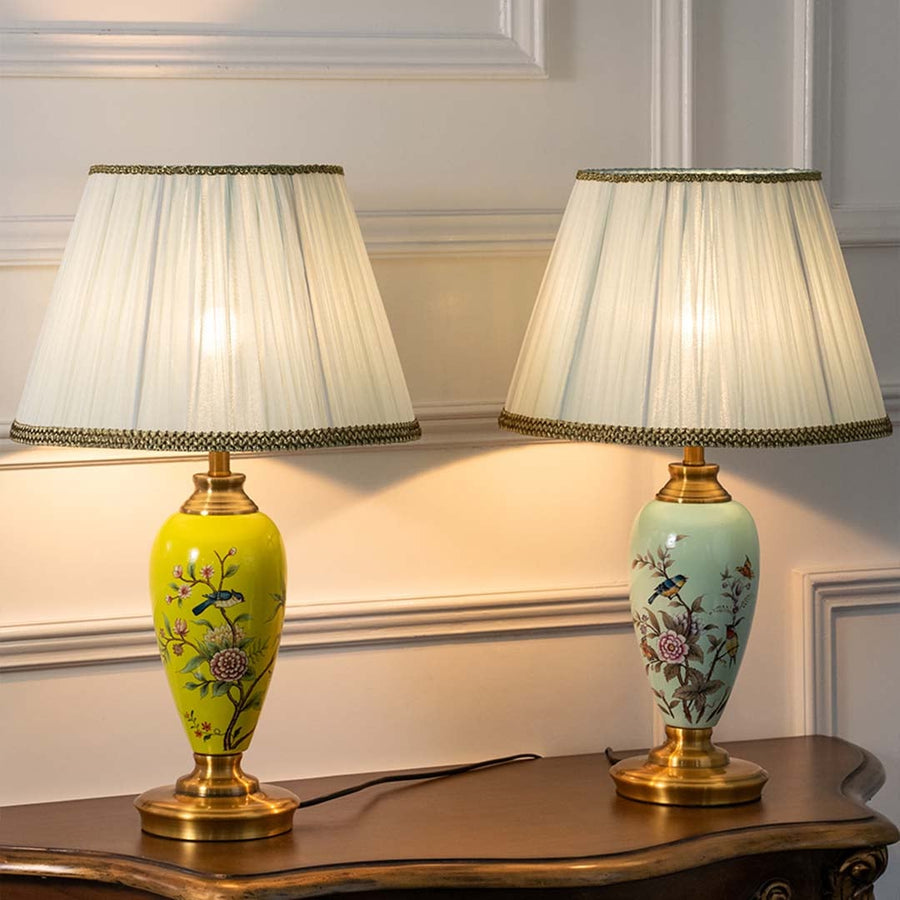 Four floral ceramic lamps with golden bases and pleated white shades glowing warmly against beige background creating a luxurious ambient setup.