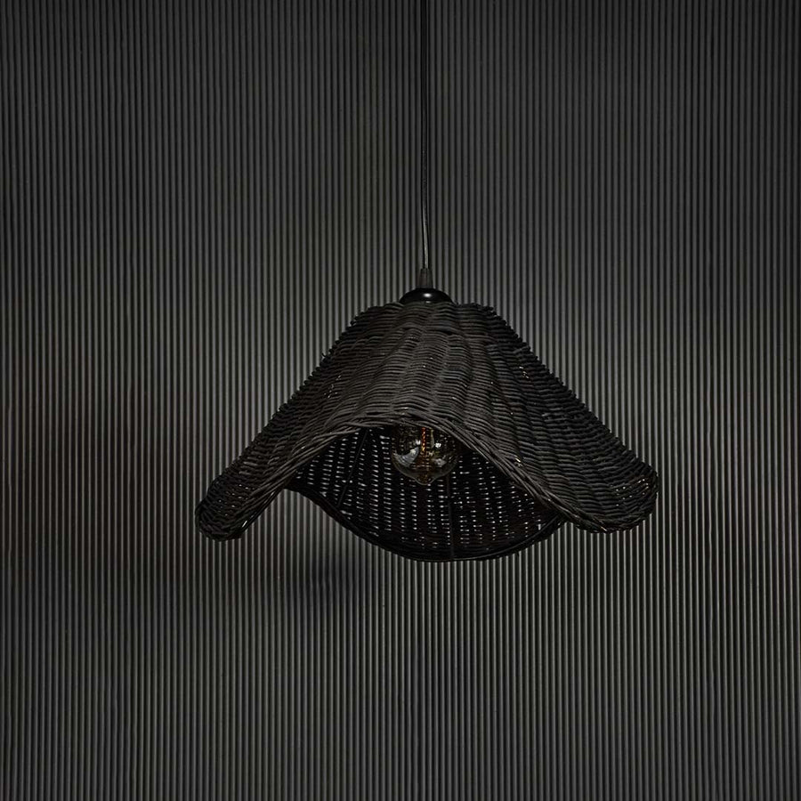 Black rattan pendant light on black background highlighting its sculptural form and fine weave detailing.