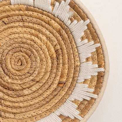 Detailed closeup view of the tight coil weaving and white wrapped sections on the natural seagrass wall basket surface quality.