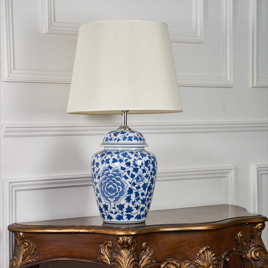 Blue and white ceramic table lamp with floral design displayed on a white background showing its detailed pattern and classic form.