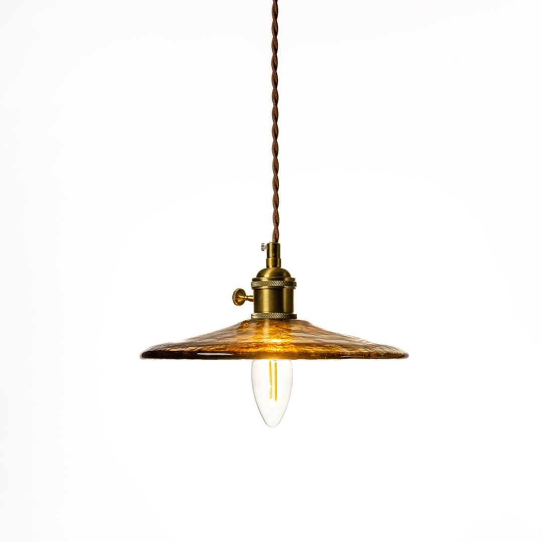 Classic brass pendant light with a textured metal shade displayed on white background highlighting its antique finish and minimalist design.