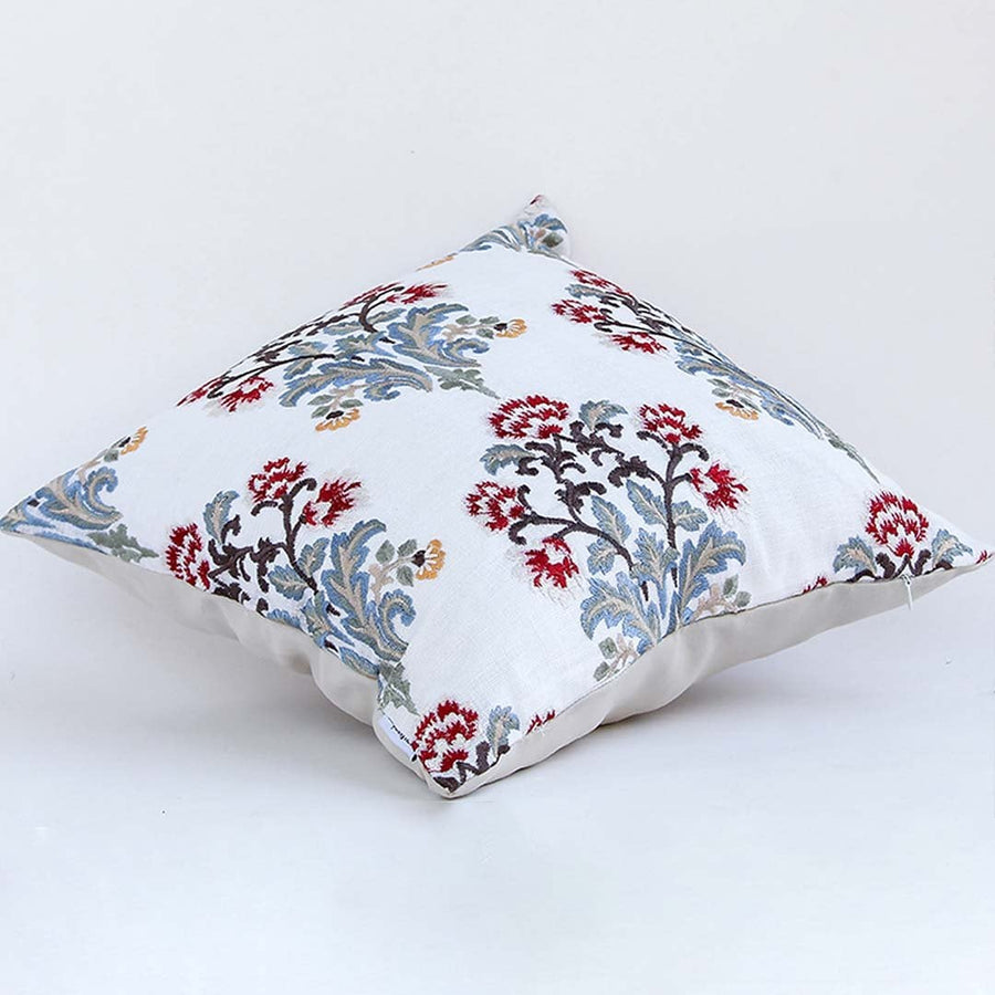 Soft cotton cushion cover with detailed red and blue floral embroidery displayed at an angle offering a vibrant nature inspired décor touch with a breathable gentle and skin friendly fabric feel.