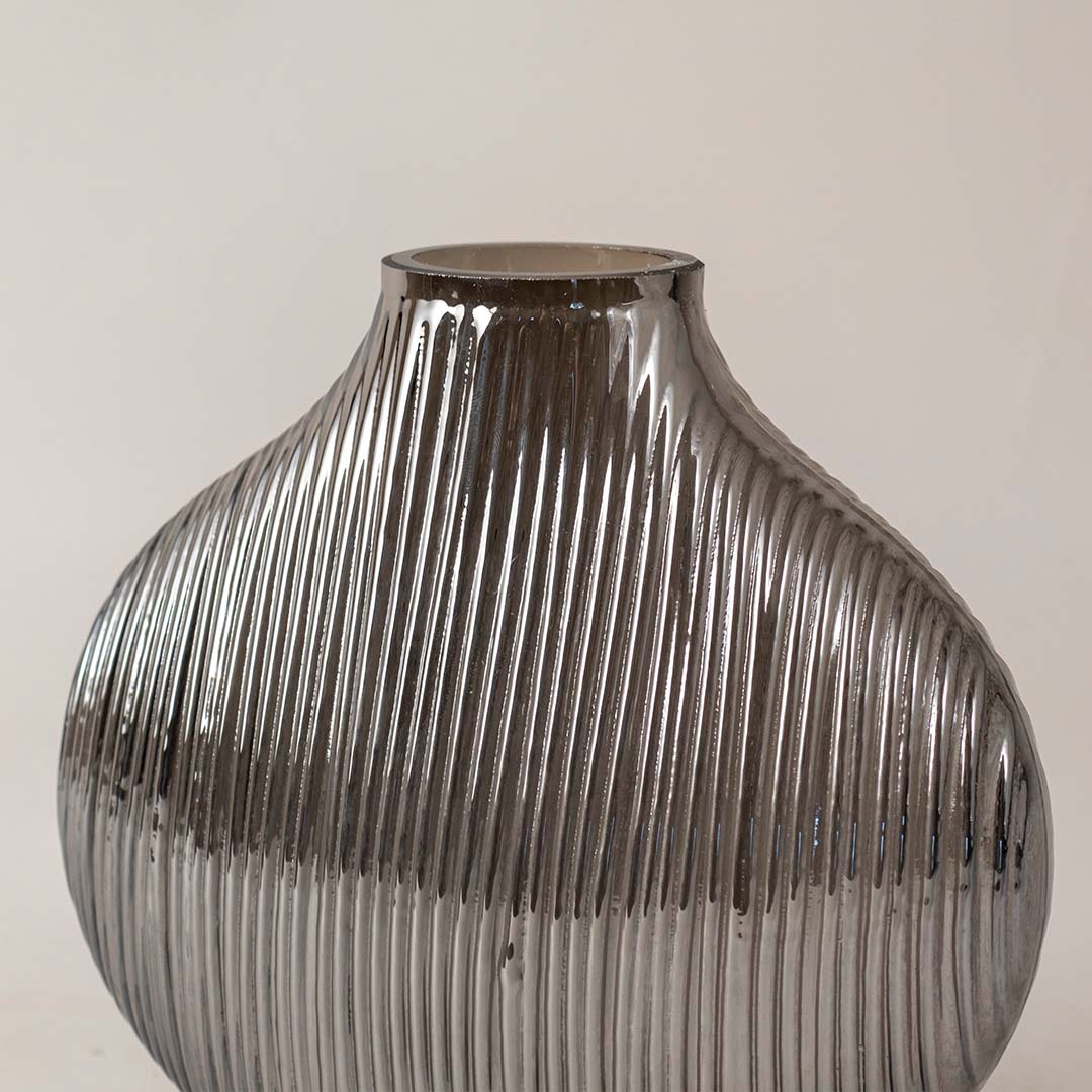 Textured smoked grey glass vase with vertical ribbing design adds contemporary style to any living room shelf decor.