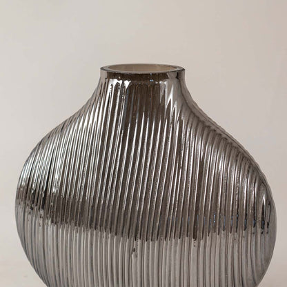 Textured smoked grey glass vase with vertical ribbing design adds contemporary style to any living room shelf decor.