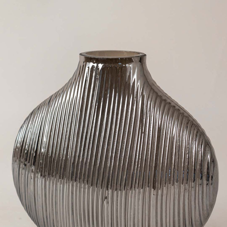Textured smoked grey glass vase with vertical ribbing design adds contemporary style to any living room shelf decor.