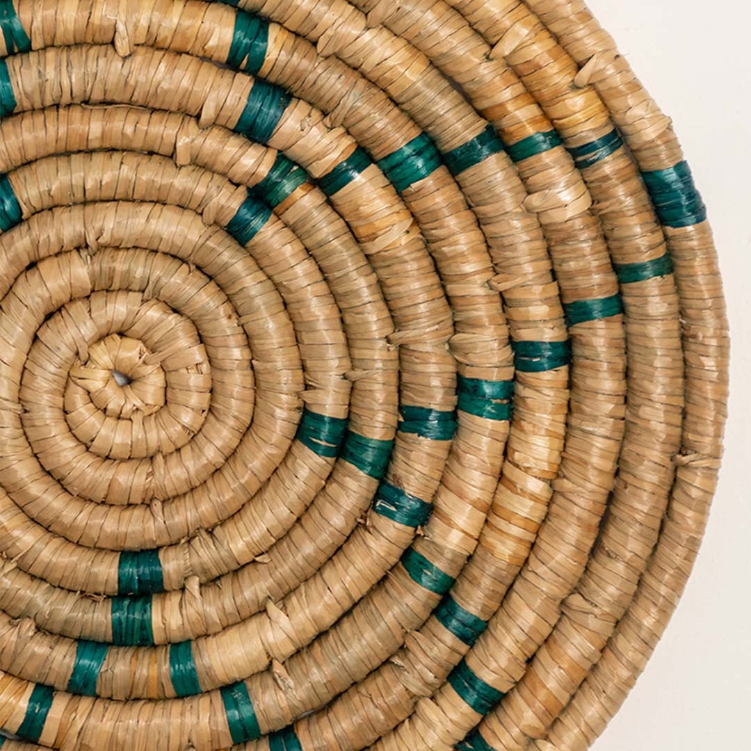 Detailed closeup view of the tight coil weaving and teal stitched accents on the natural seagrass wall basket surface quality.