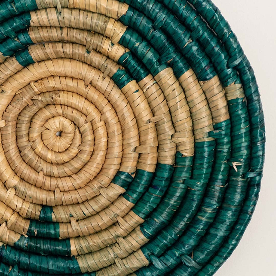 Detailed closeup view of the tight coil weaving and teal stitched accents on the natural seagrass wall basket surface quality.