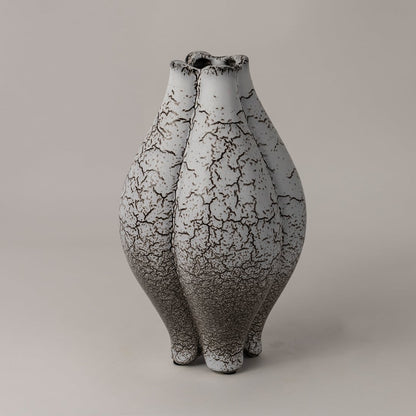 Side view of crackle ceramic vase showing its sculptural curves and intricate black crackle pattern on white glaze finish.