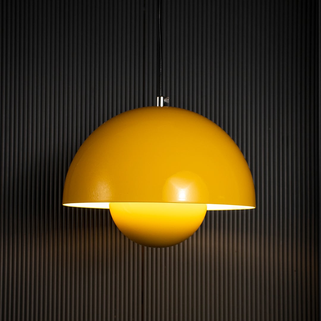 Dome pendant lights glowing against black background warmly over a modern dining table creating a relaxed contemporary mood.