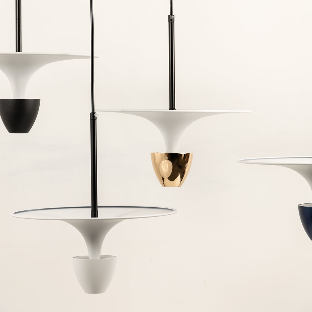 White and black metal pendant lights illuminated to showcase modern decorative ceiling lighting with elegant appeal.