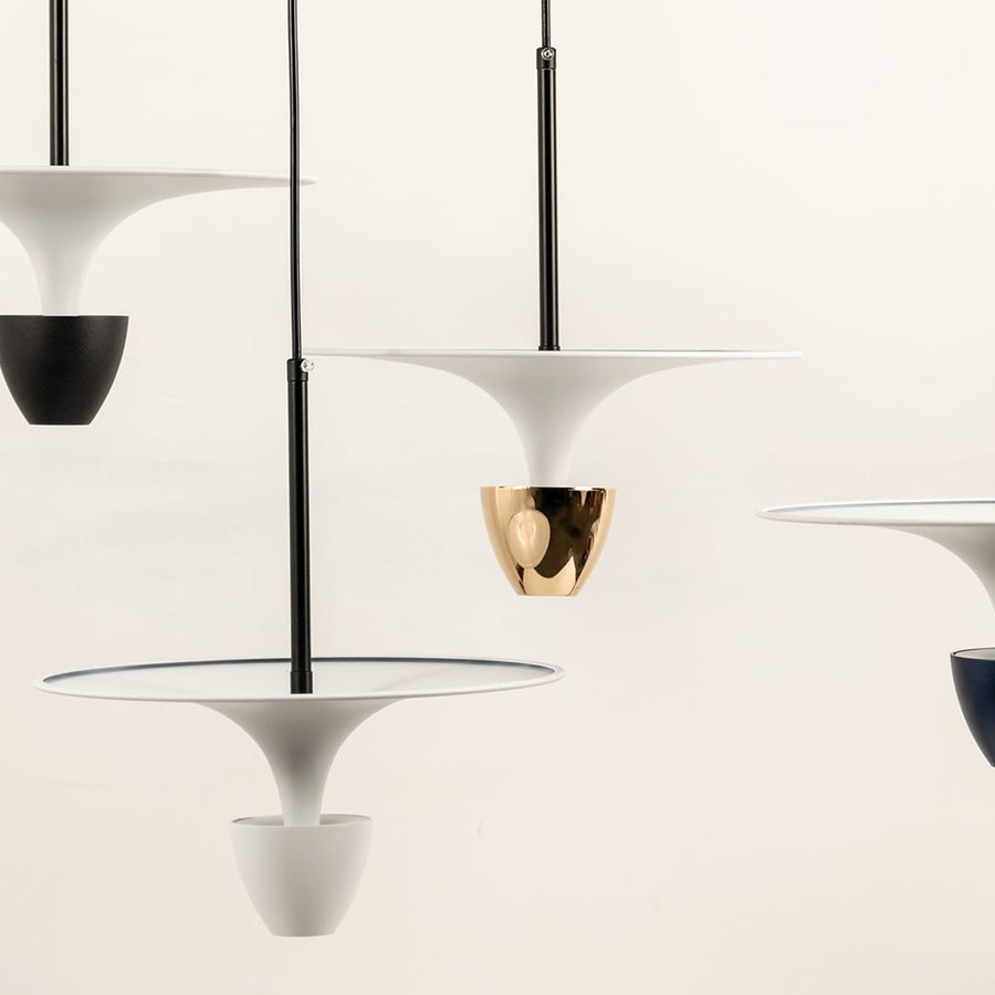 White and black metal pendant lights illuminated to showcase modern decorative ceiling lighting with elegant appeal.
