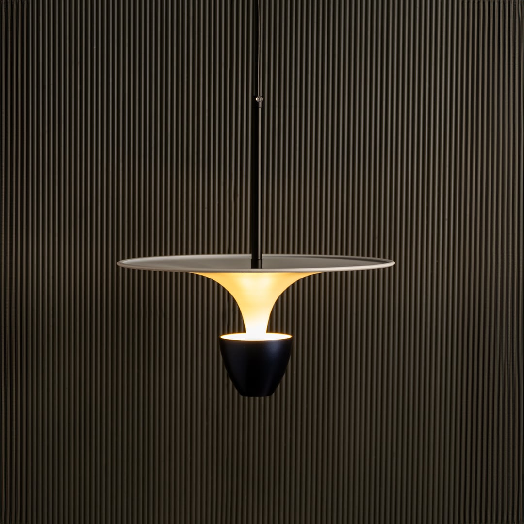 Gold metal pendant light illuminated warmly creating luxurious ambiance for modern indoor spaces.