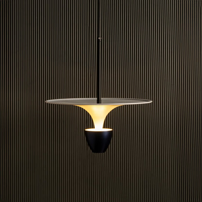 Gold metal pendant light illuminated warmly creating luxurious ambiance for modern indoor spaces.