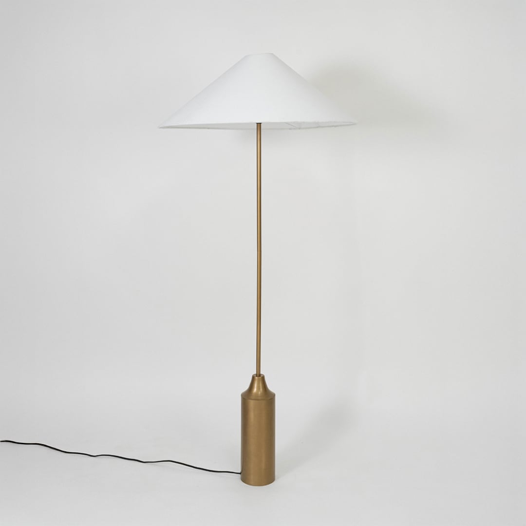 Wide conical white lampshade paired with brass rod delivering clean minimal style and evenly diffused lighting.