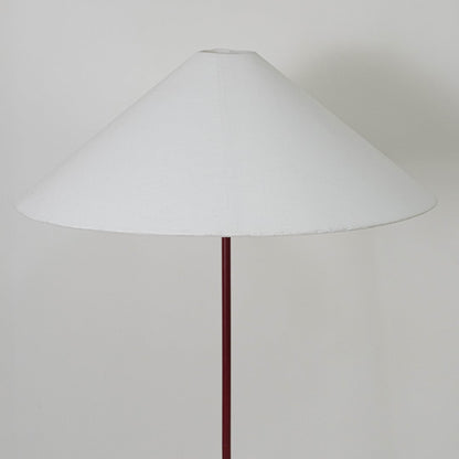 Large white conical lampshade supported by slim maroon rod designed to diffuse warm ambient light elegantly.