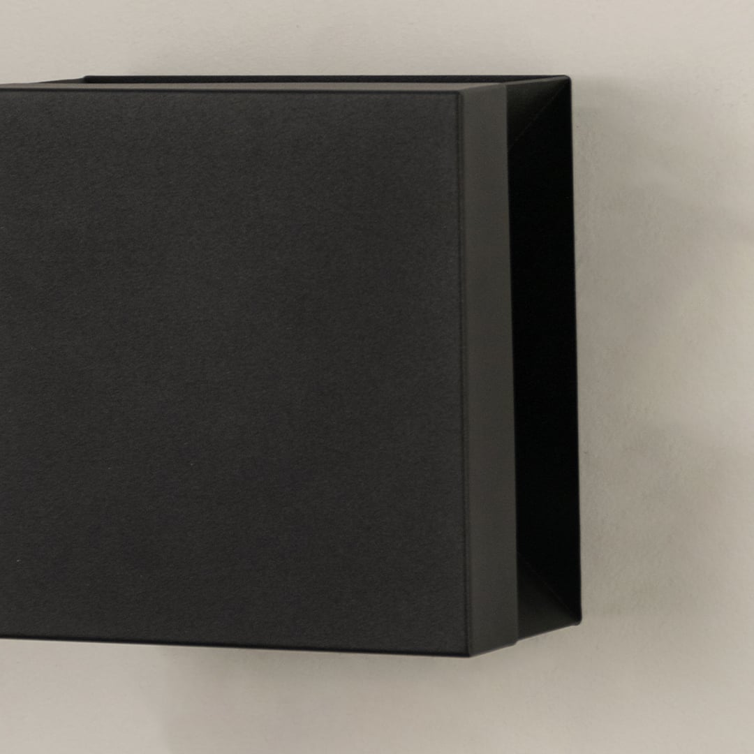 Closeup view of matte black metal finish and clean geometric lines of the modern square outdoor wall lighting fixture design.