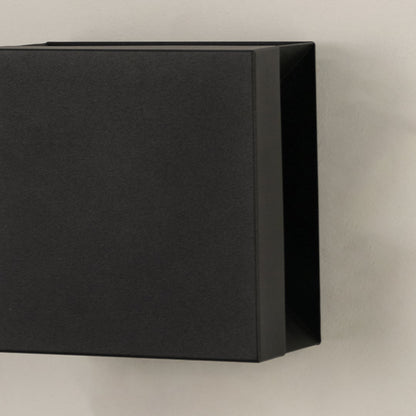 Closeup view of matte black metal finish and clean geometric lines of the modern square outdoor wall lighting fixture design.