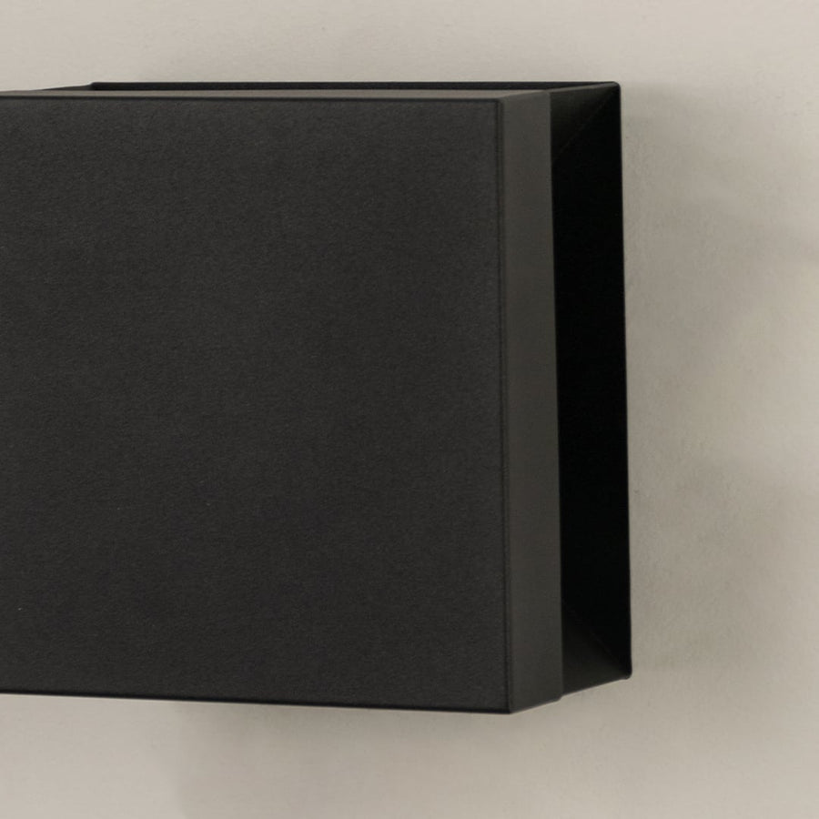 Closeup view of matte black metal finish and clean geometric lines of the modern square outdoor wall lighting fixture design.