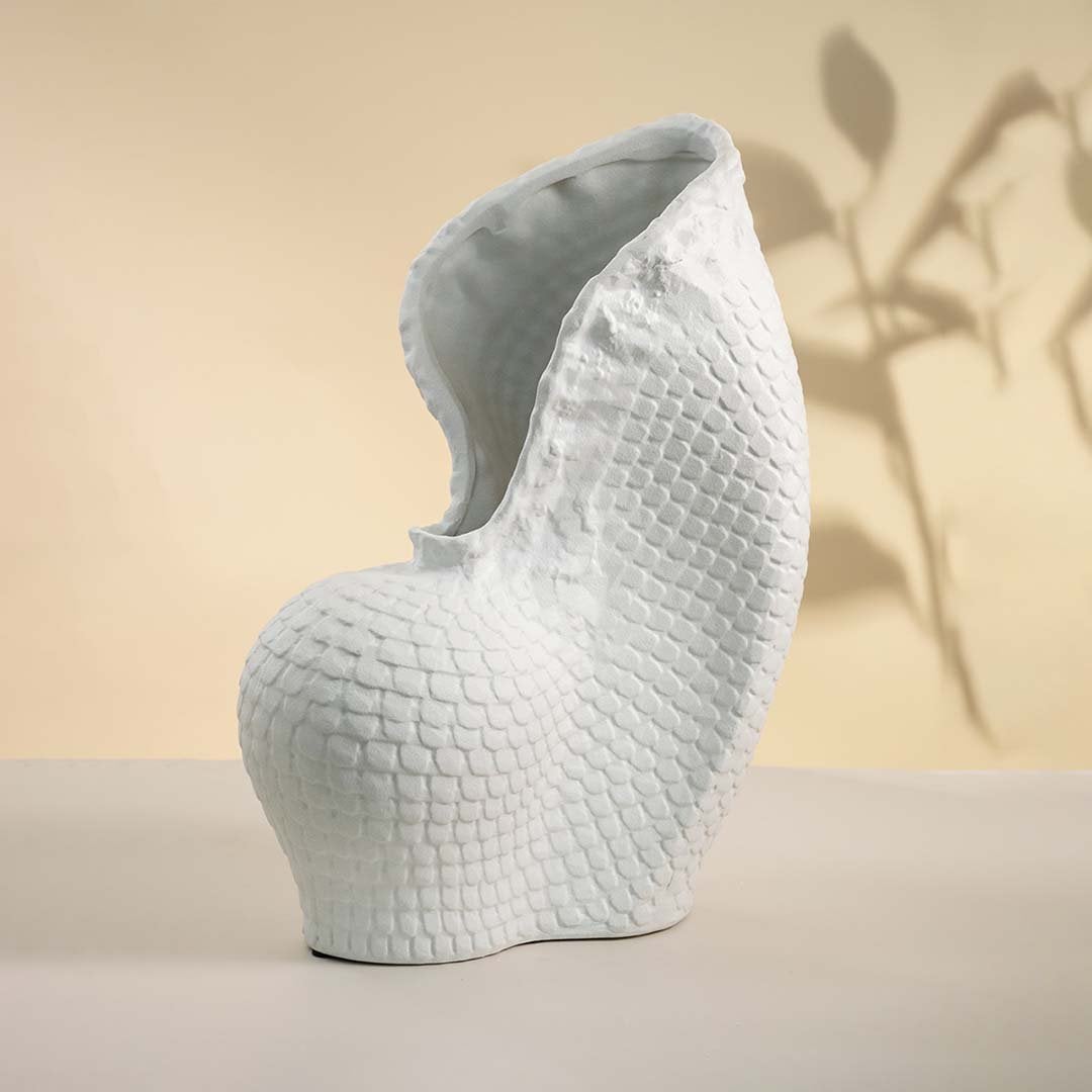 Sculptural white ceramic vase with unique curved shape showcased on white background perfect for modern home interiors.