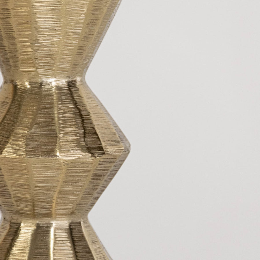 Closeup of gold metal candle holder showing textured geometric detailing for modern living room and dining decor.