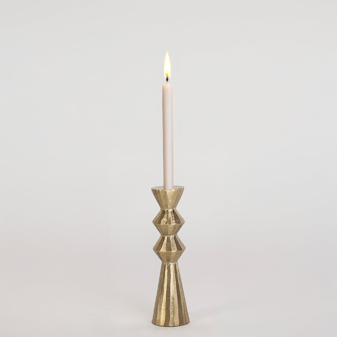 Modern gold metal candle holder with sculpted geometric design displayed on a clean white background for decor.
