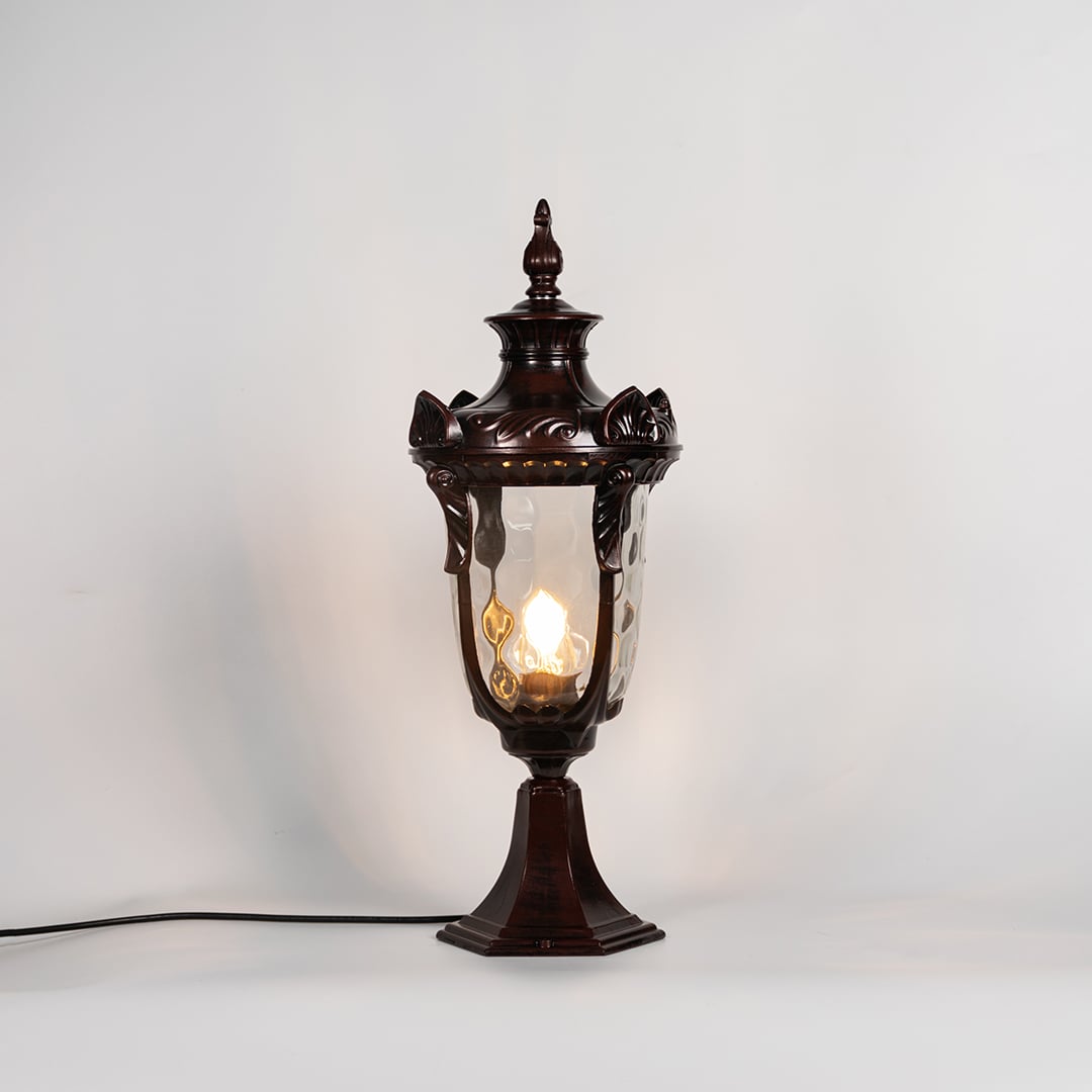 Brown pillar lamp glowing with warm bulb and glass panels shown on white background for stylish outdoor garden lighting.