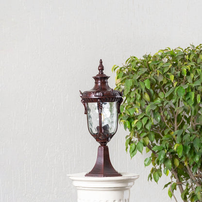 Antique brown pillar light with carved detailing and patterned glass displayed off on white background highlighting classic style.