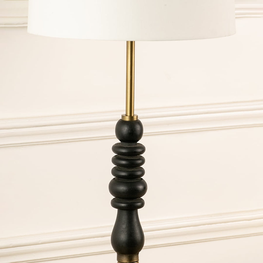 Black turned wood lamp stem with brass rod detail showcasing refined craftsmanship and timeless decorative appeal.