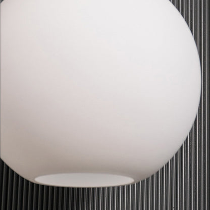 A closeup view of the gold and white pendant light showing the frosted glass texture and polished gold sphere detail ideal for premium interiors.