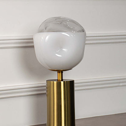 White glass globe table lamp showcasing smooth frosted glass craftsmanship with brass metal base and contemporary design.