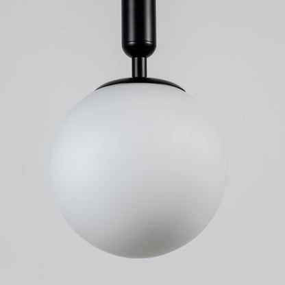 White glass globe pendant light with black metal fixture showcasing smooth opal finish and refined modern craftsmanship.