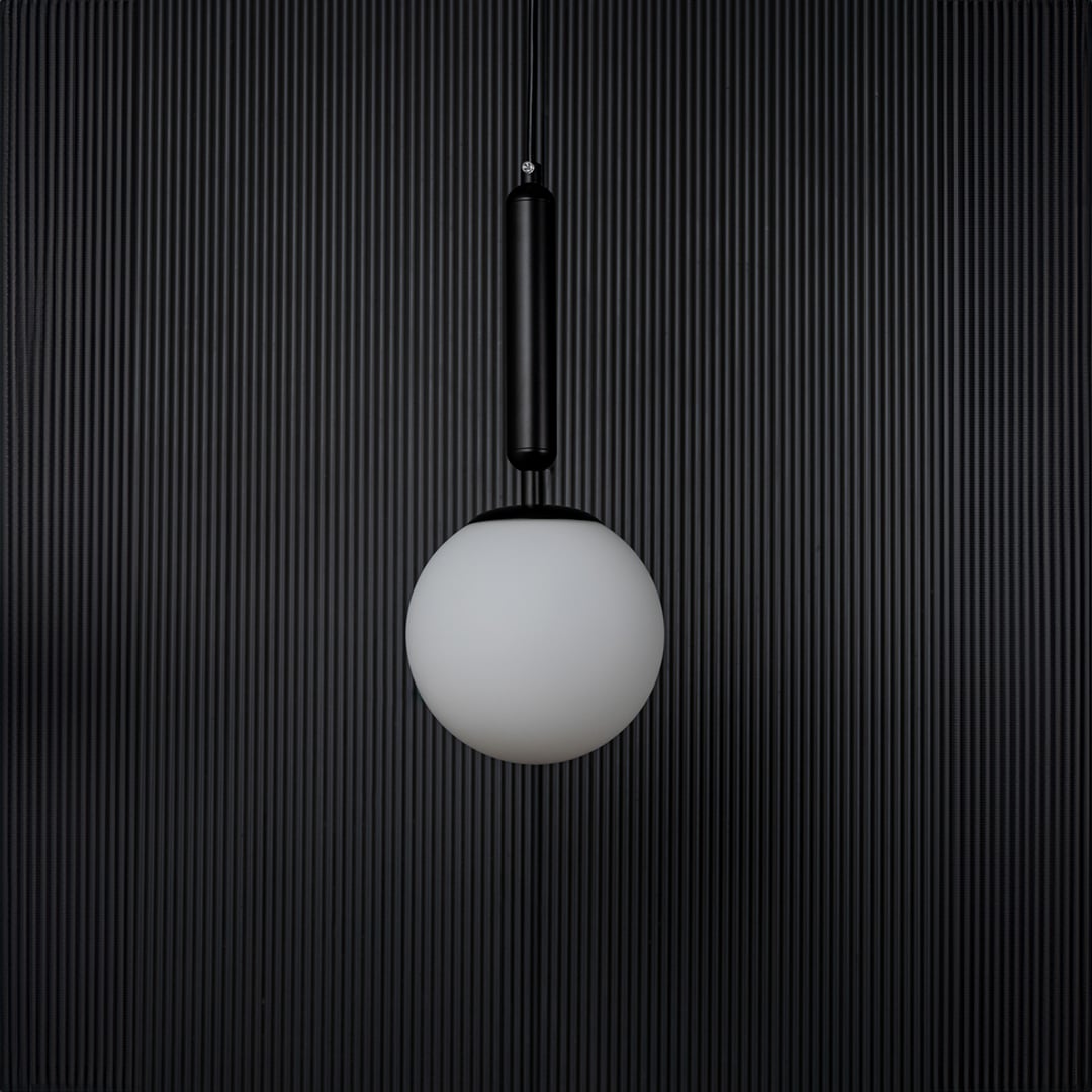 A contemporary pendant light with the bulb off shown on a deep black background highlighting the matte texture and clean geometric shape of the lighting piece.