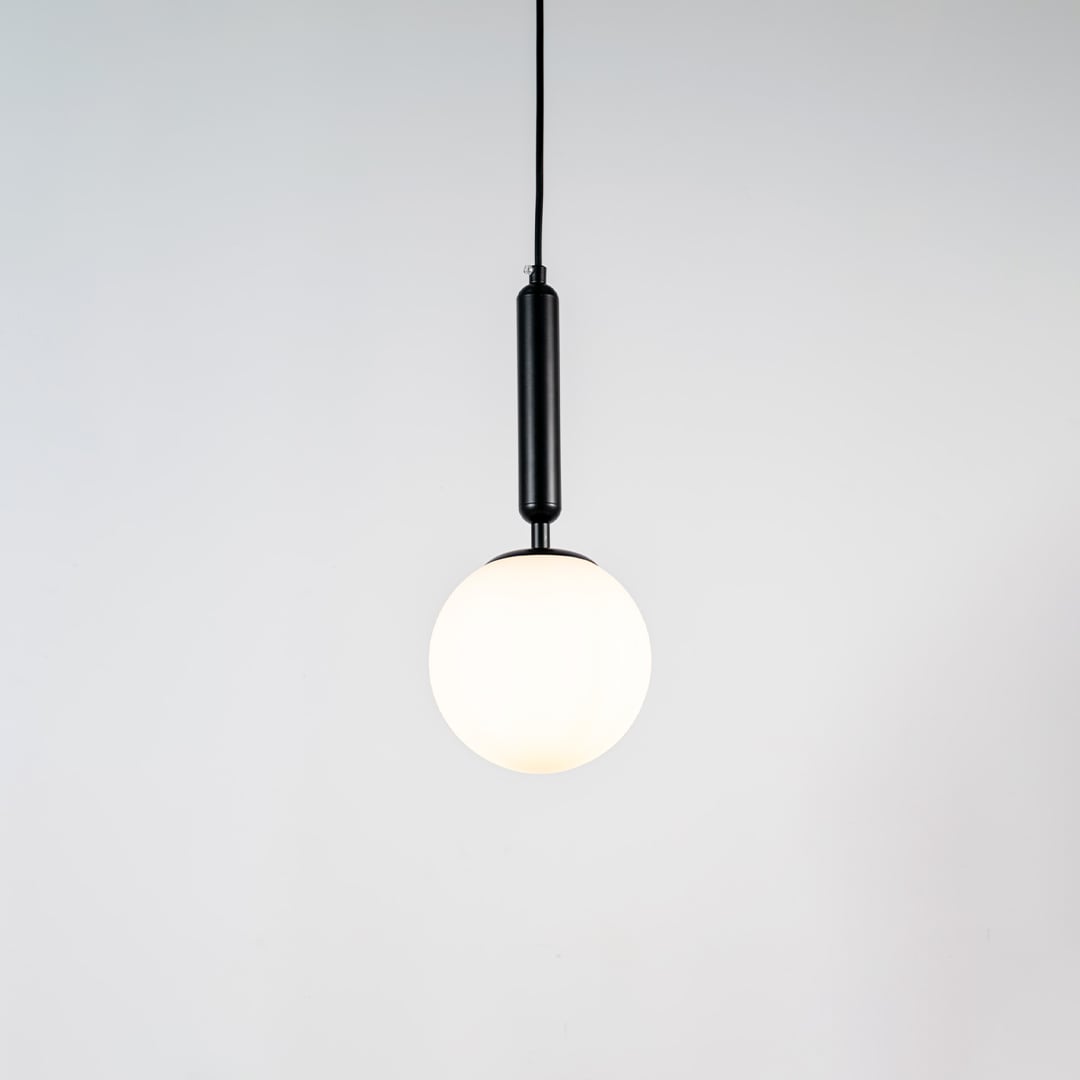 White glass globe pendant light with black metal holder and minimalist design for elegant contemporary ceiling lighting decor.