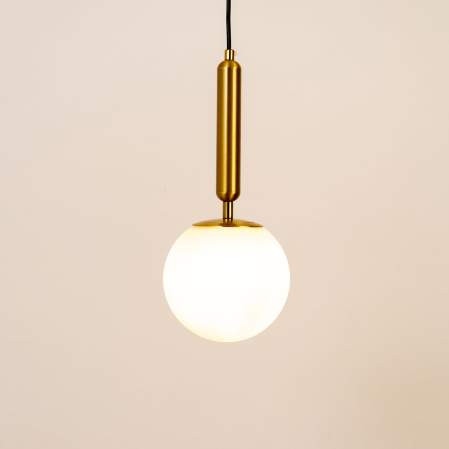 White glass globe pendant light with brass metal holder and minimalist design for elegant contemporary ceiling lighting decor.