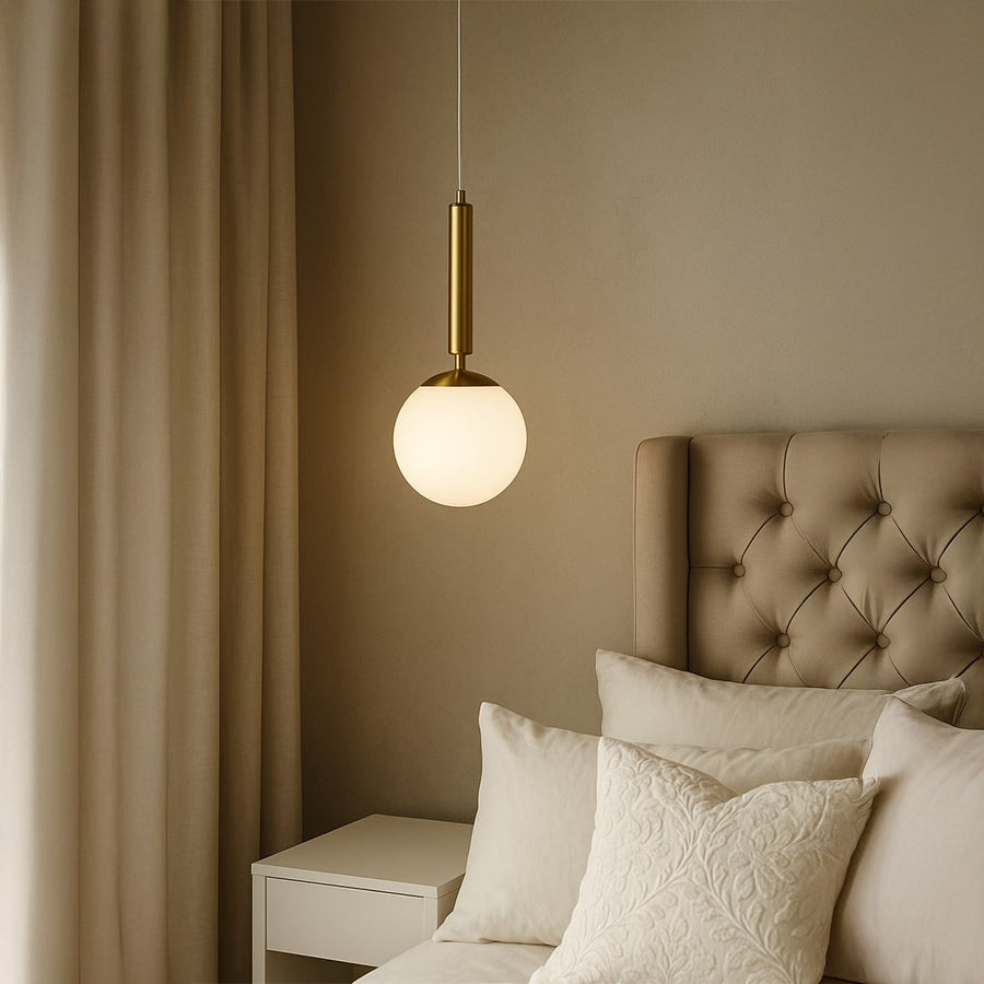 White glass pendant light beside bed adding soft ambient lighting and contemporary elegance to modern bedroom decor.