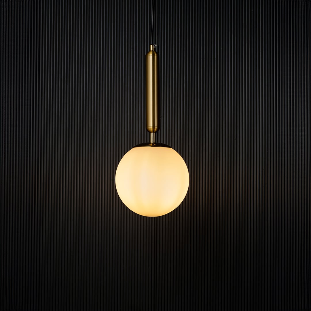 Modern pendant light glowing warmly against a dark background creating a striking contrast that highlights its elegant gold and white finish.