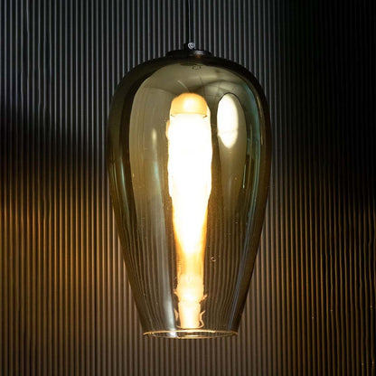 An amber glass pendant light glowing warmly against a dark textured backdrop creating a rich ambient lighting effect for stylish interior decor.