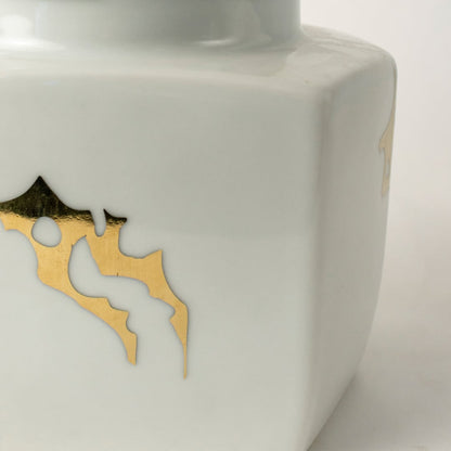 Closeup of white ceramic decorative jar with gold bee motif showcasing premium craftsmanship and elegant detailing.