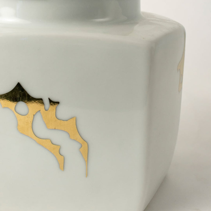 Closeup of white ceramic decorative jar with gold bee motif showcasing premium craftsmanship and elegant detailing.