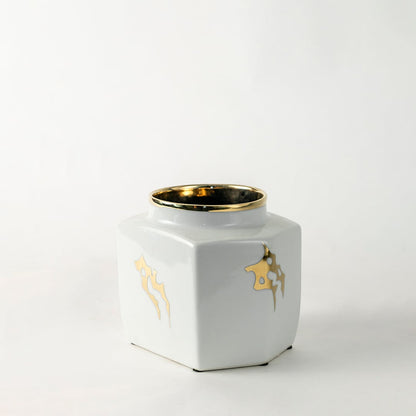 White ceramic decorative storage jar with gold bee artwork and gold rim for elegant shelf styling and home decor.