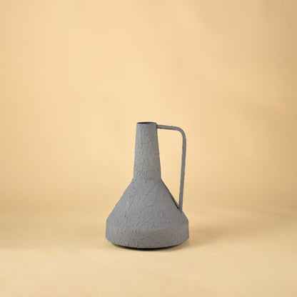 Textured gray ceramic jug with metal handle perfect for dried flower arrangements and modern home decoration on soft neutral backdrop.