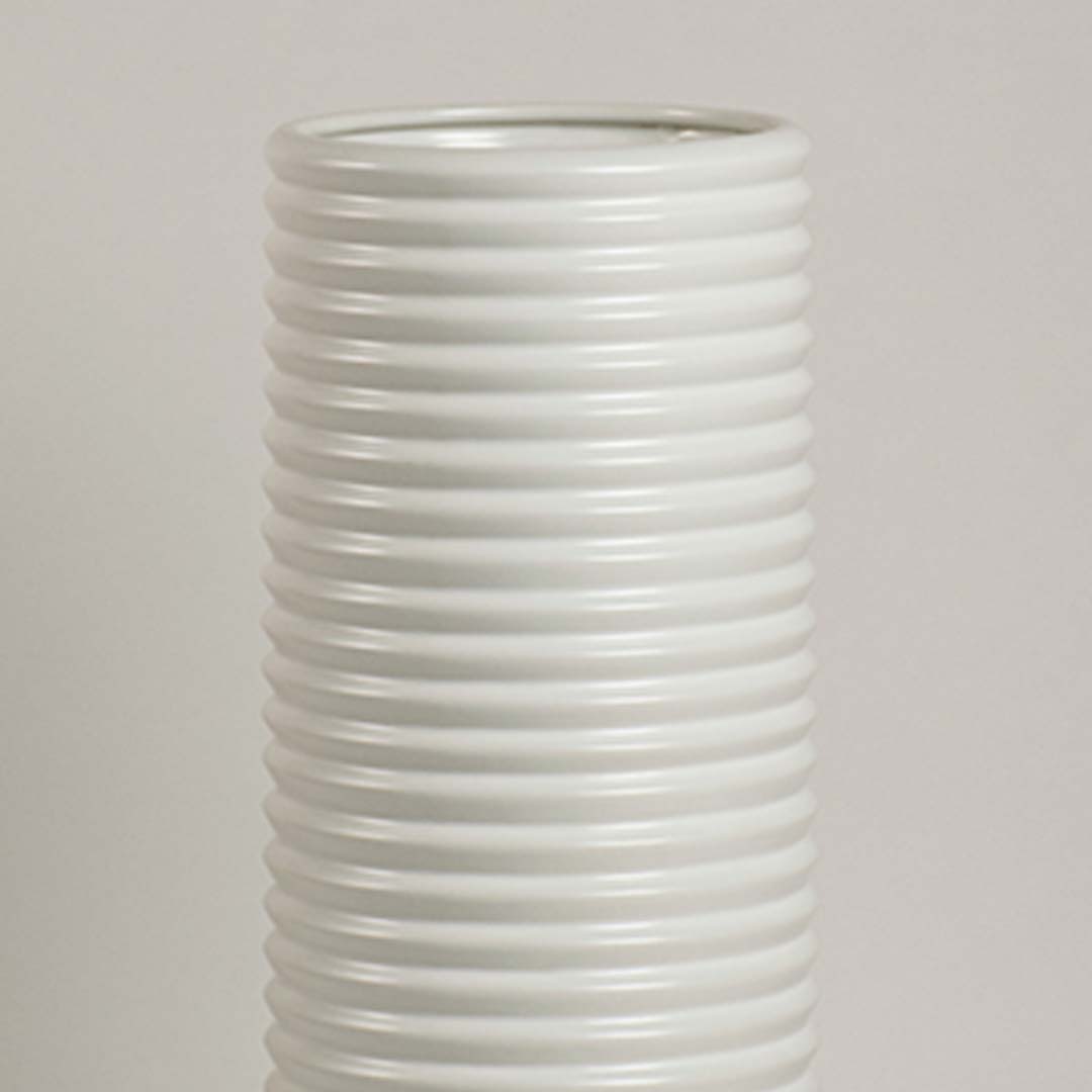 Closeup of white ceramic vase showing ribbed detailing and smooth handcrafted finish for minimalist artistic appeal.